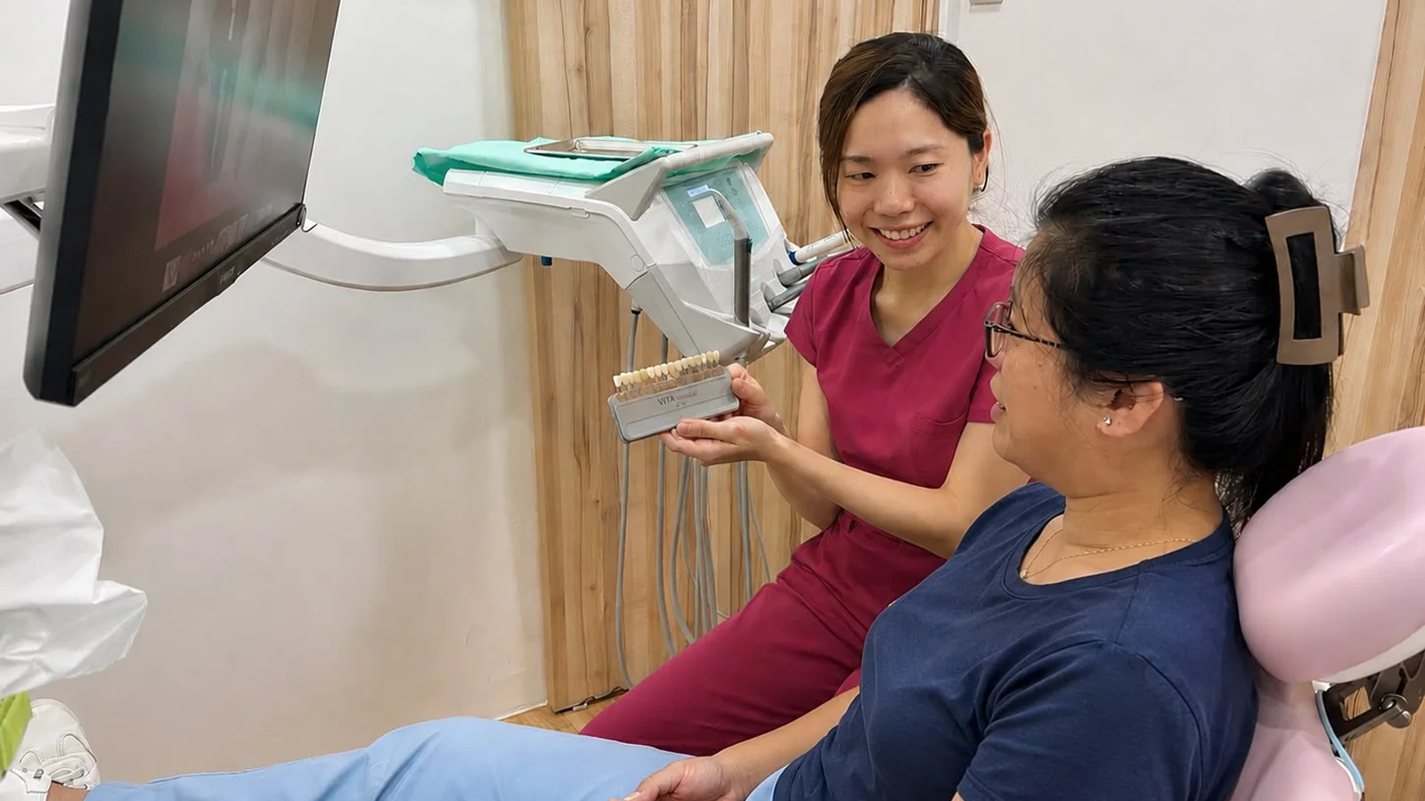 A Caring Dental dentist matching tooth shades with a patient using a shade guide