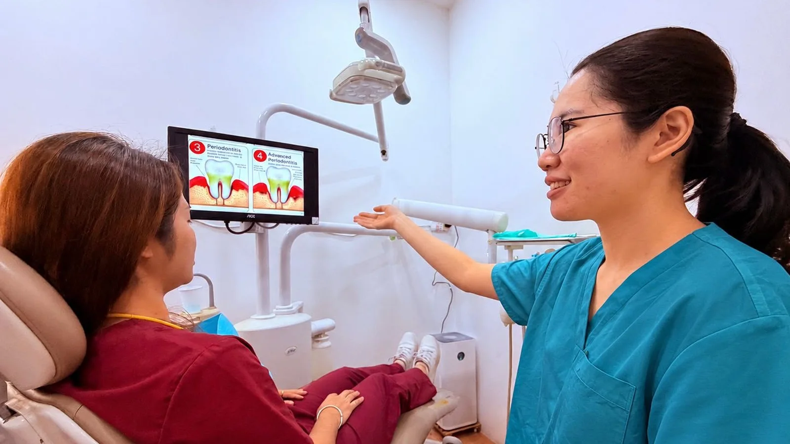 A Caring Dental dentist explaining the stages of gum disease to a patient on a chairside screen