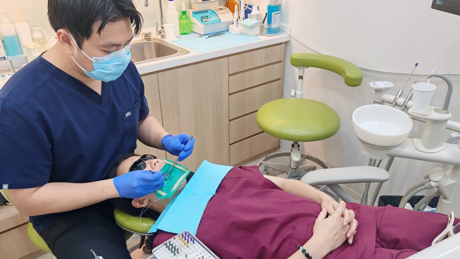 A Caring Dental dentist performing root canal treatment on a patient with a rubber dam in place